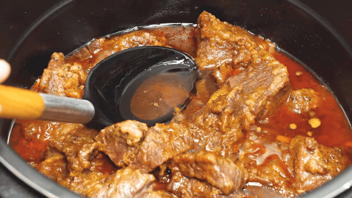 Skimming the fat from the surface of the stew.