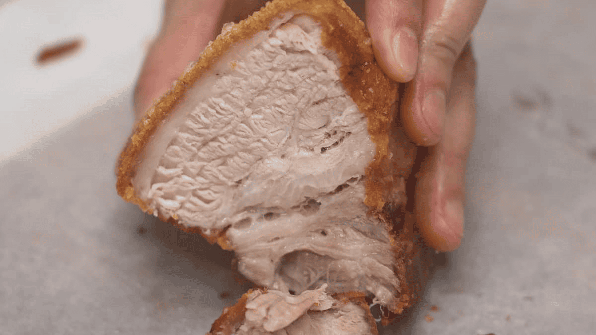 Sliced Lechon Kawali (Fried Pork Belly) on a parchment paper-lined cutting board.