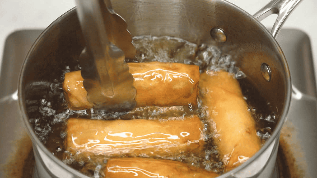 Deep-frying the Lumpiang Gulay (Fried Vegetable Spring Rolls) in a saucepan.