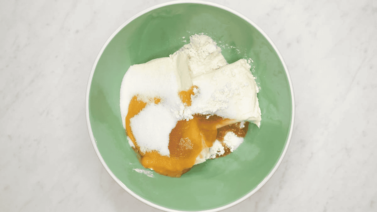 Combining the cheesecake batter ingredients in a bowl.