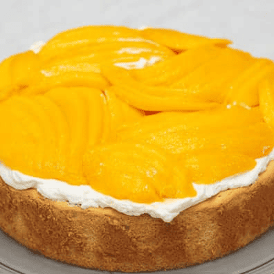 Sliced mangoes arranged over the whipped cream filling.