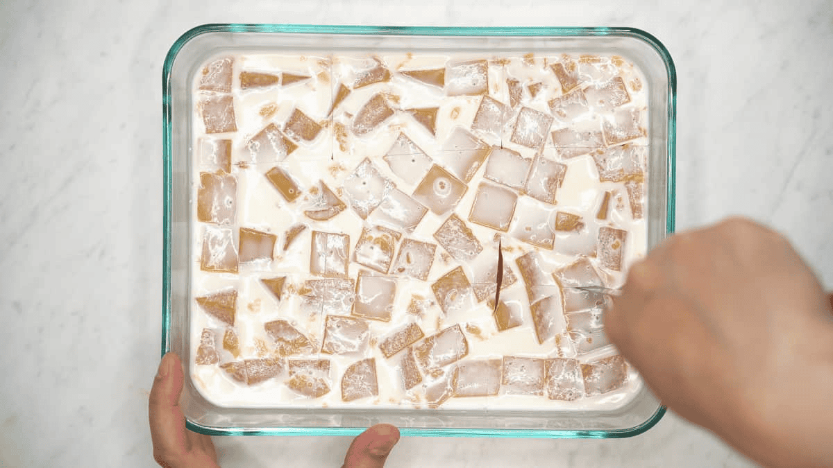Slicing the Mango Gelatin in the container.