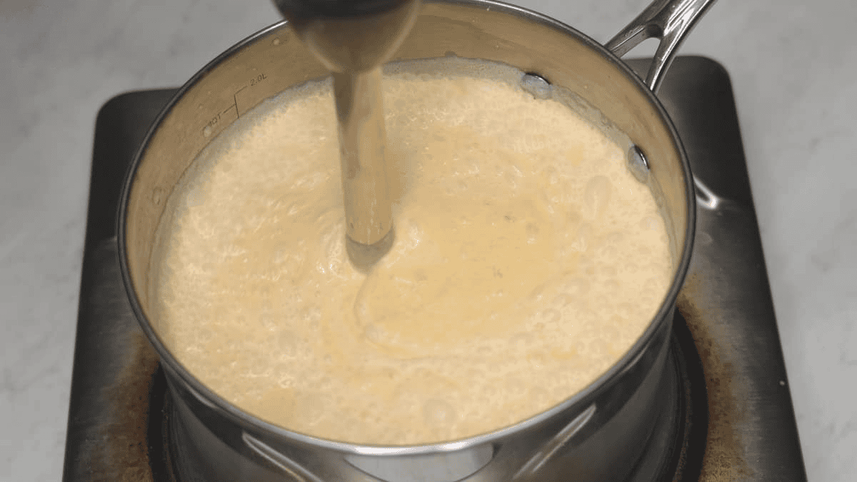 Blending the ingredients using an immersion blender.