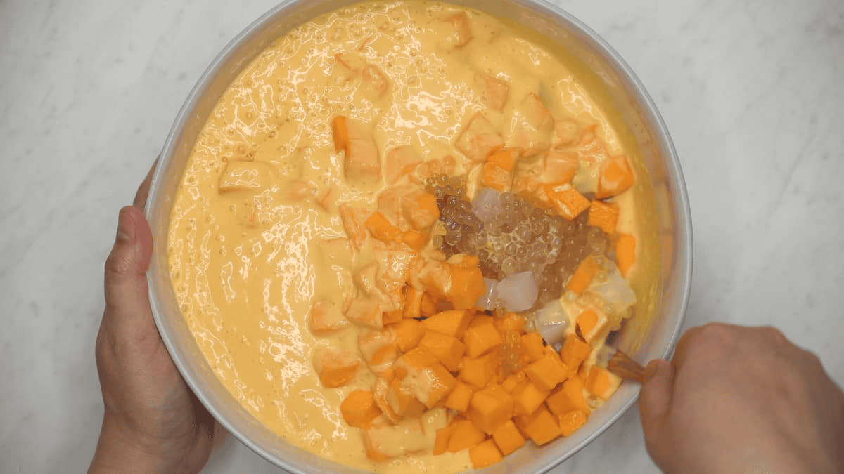 Stirring the sauce with the sago, nata de coco, and mangoes.