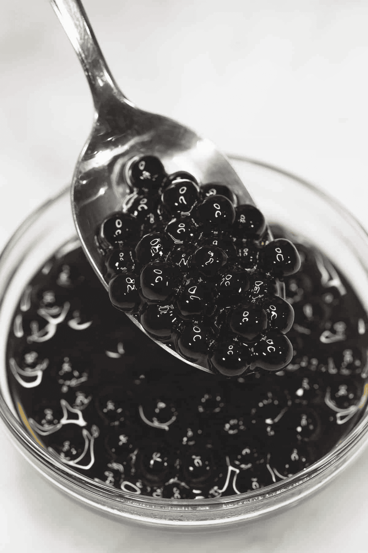 Cooked tapioca pearls in syrup on a spoon.