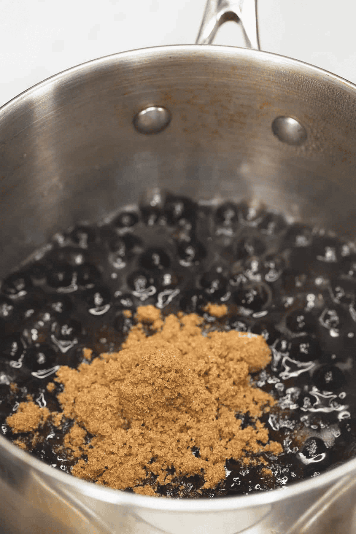 Added brown sugar to the cooked tapioca pearls in the saucepan.