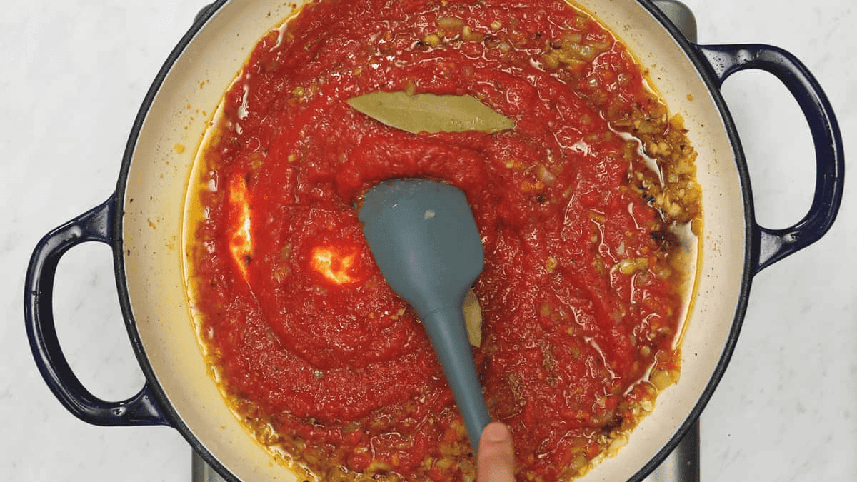 Mixing the marinara sauce in the saute pan.