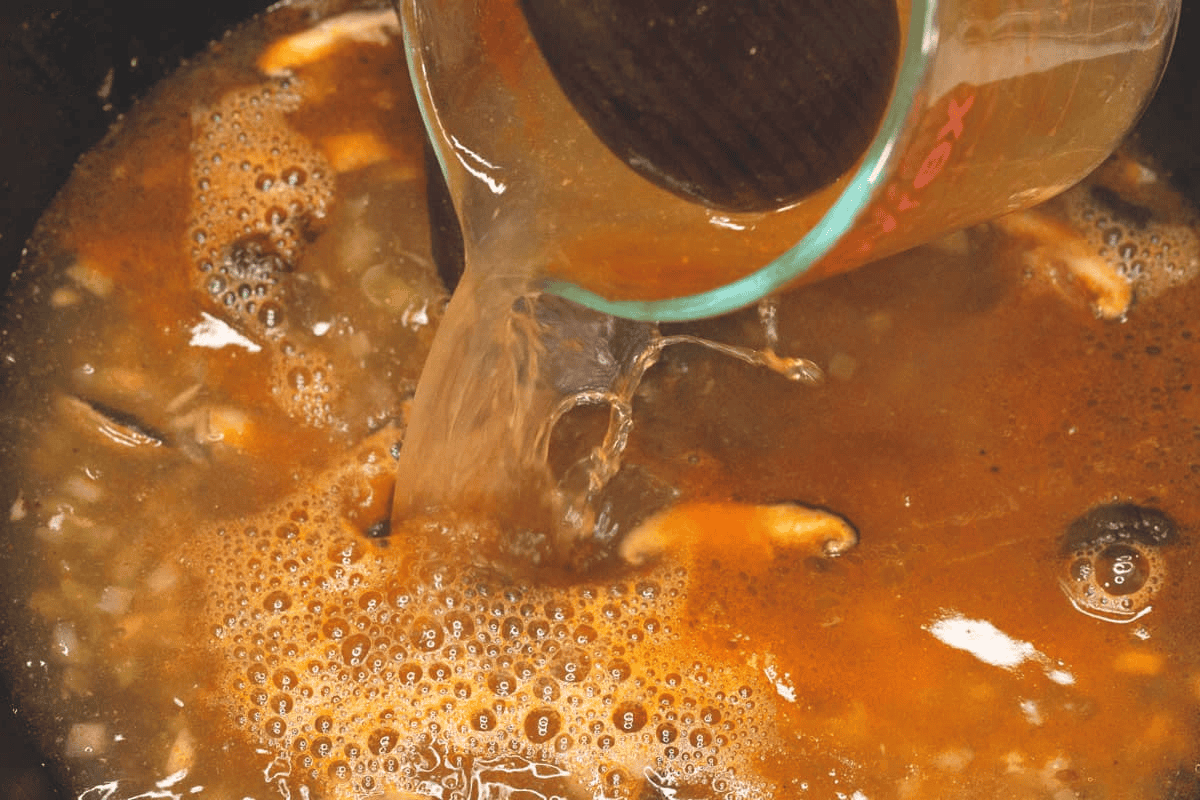 Adding the shrimp stock to the wok.