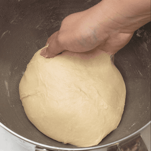 Placing dough in a bowl to rise.