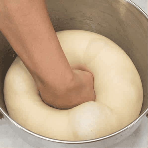 Punching down the risen dough.