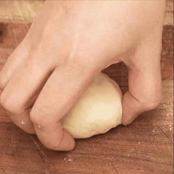 Shaping a portion of dough into a ball.