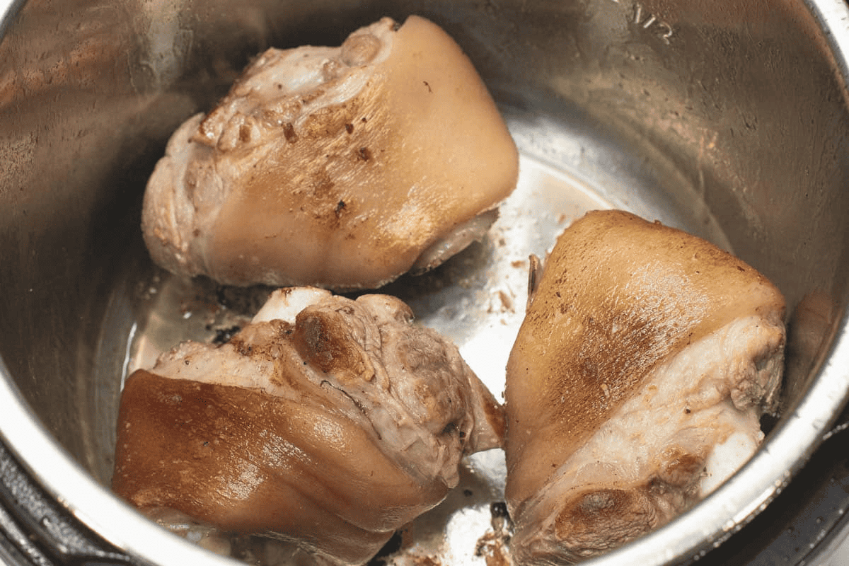 Searing the pieces of pork hock in the pot.