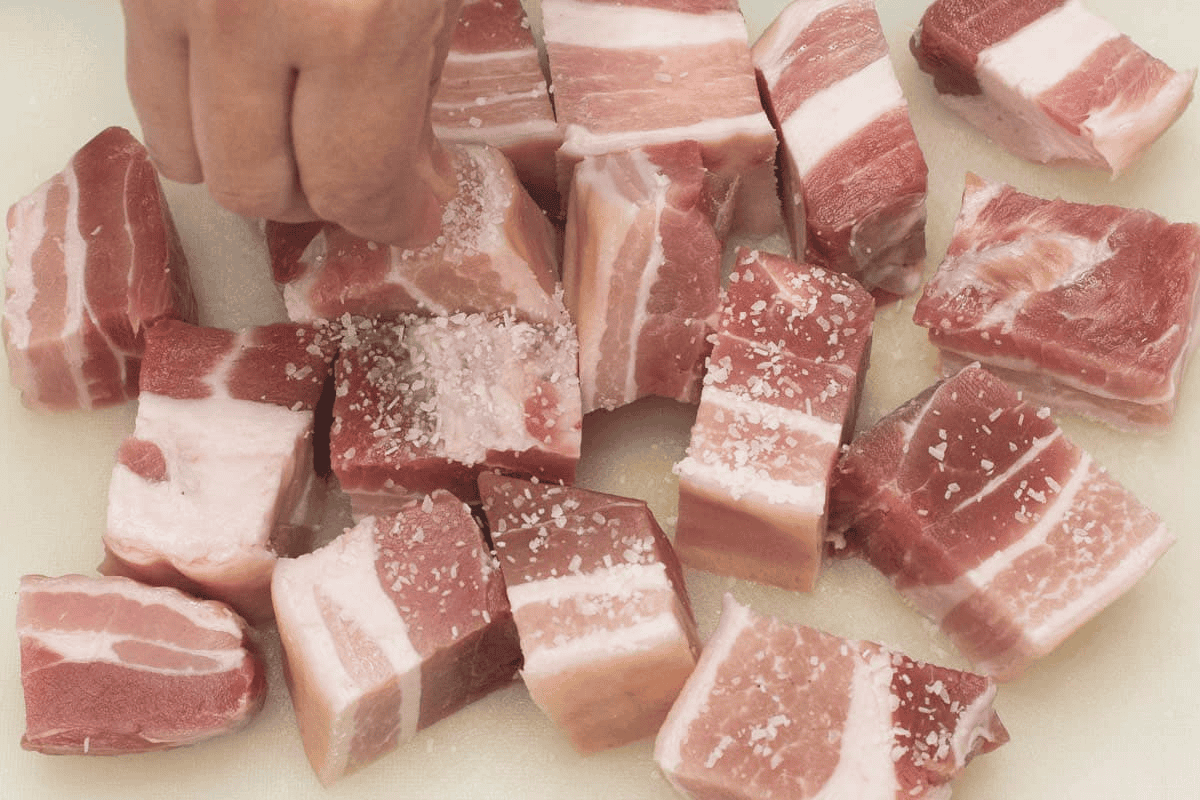 Seasoning the pork with salt.