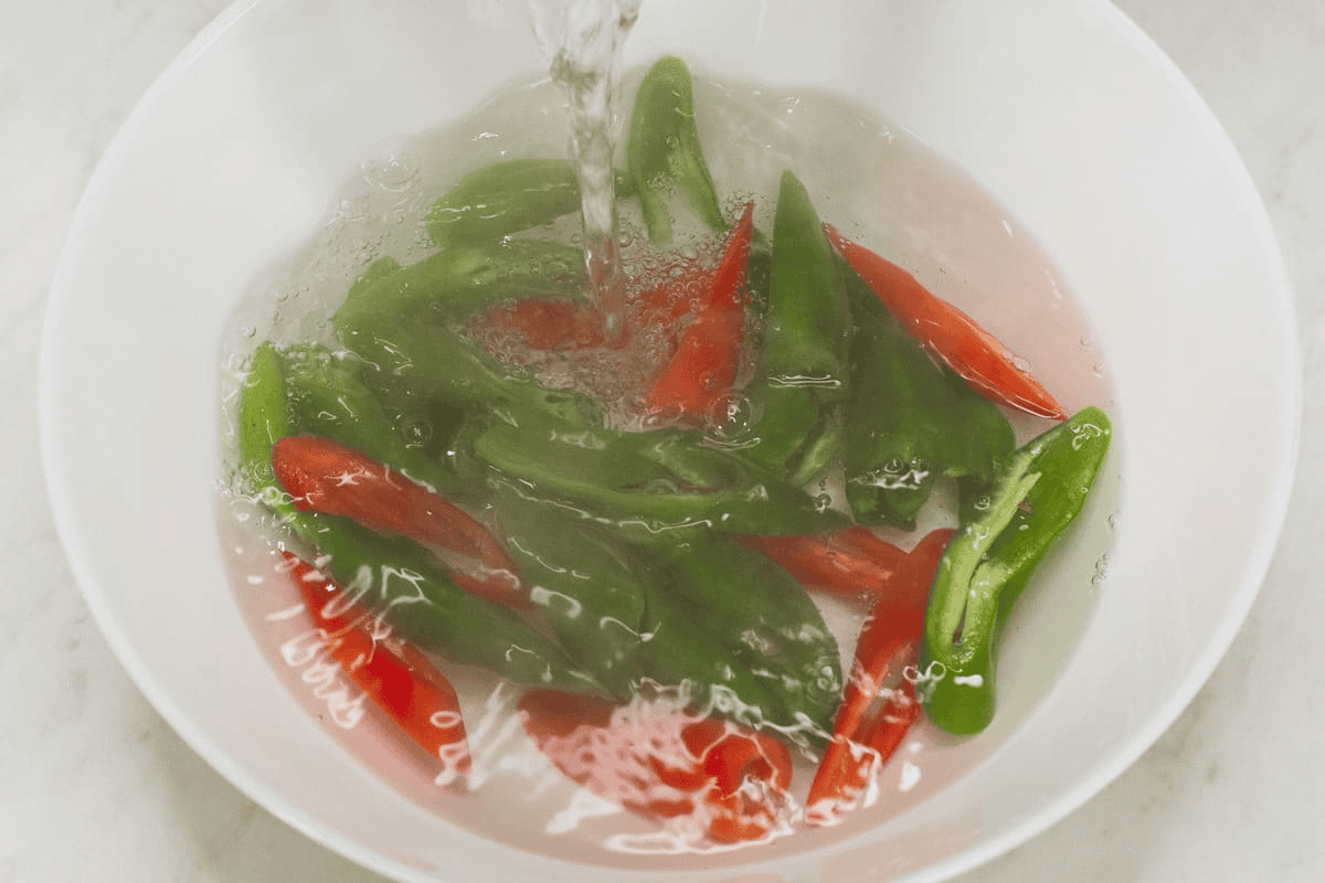 Blanching the chili peppers in hot water.