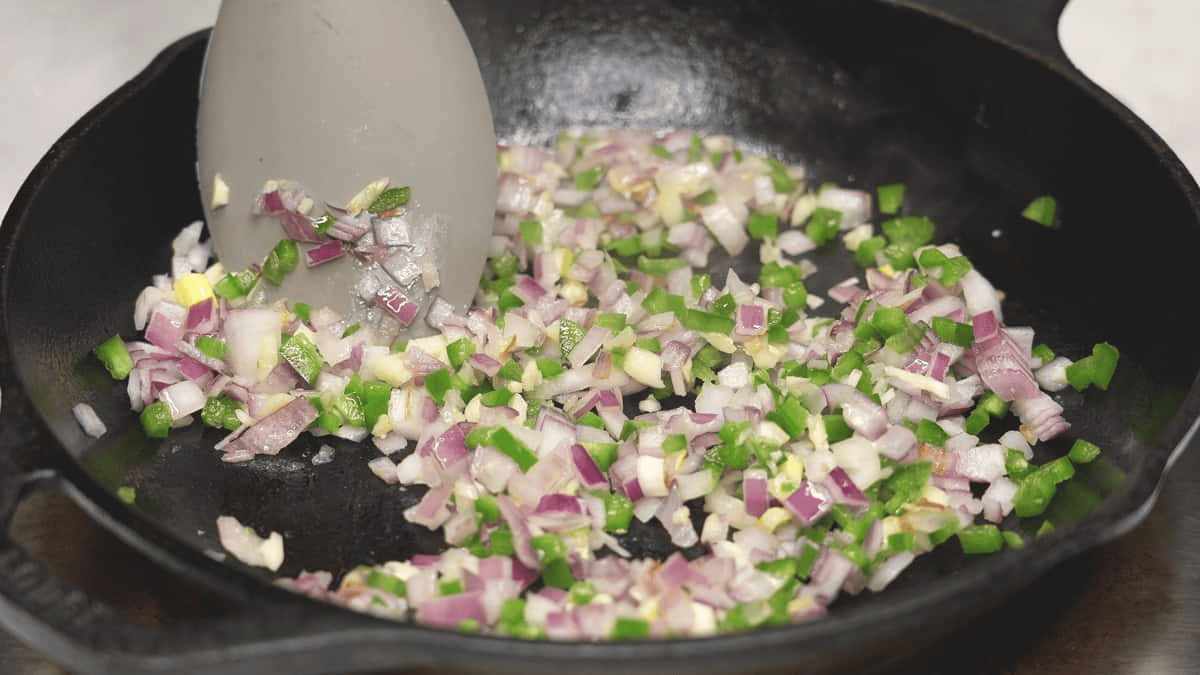 Sauteing garlic, onions, and jalapeno in a skillet.