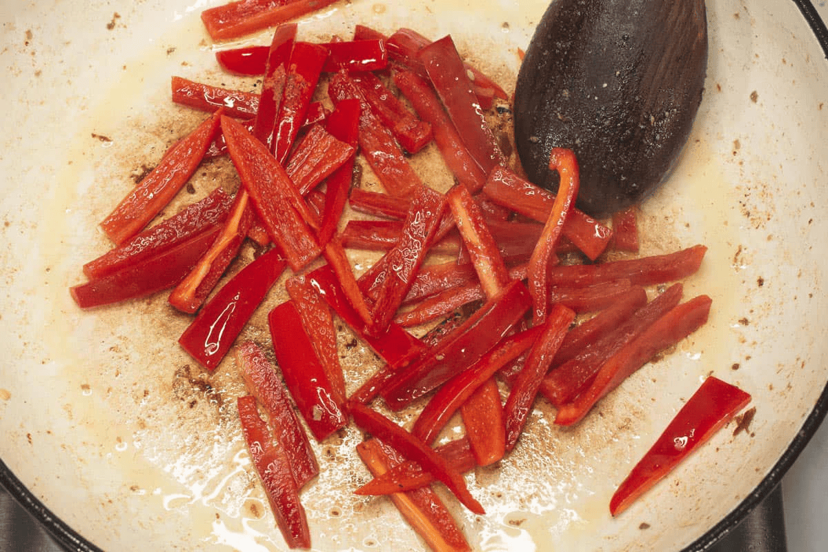 Searing the strips of red bell peppers in the saute pan.