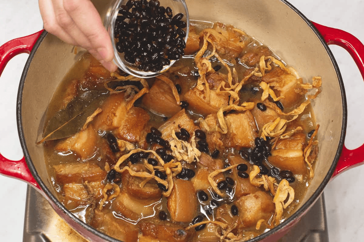 Adding salted black beans into the pot.