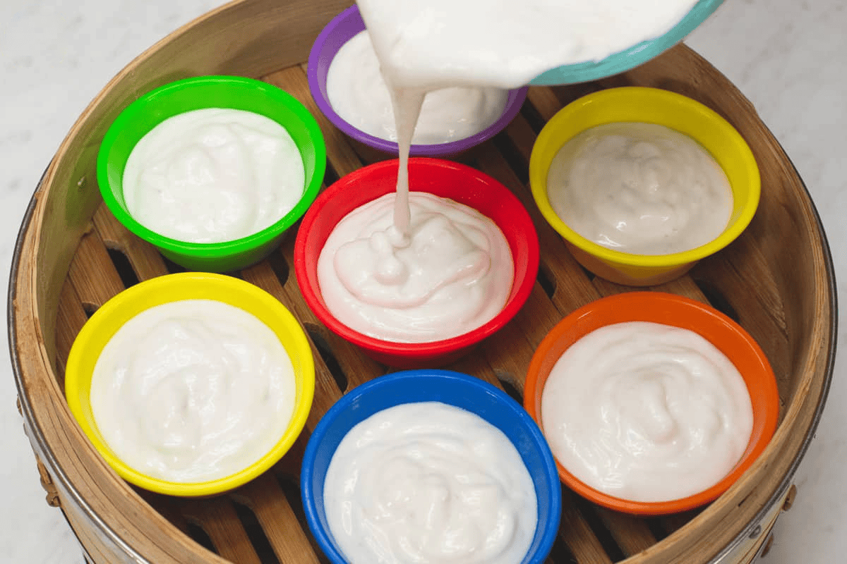 Filling the molds in the steamer basket with the batter.