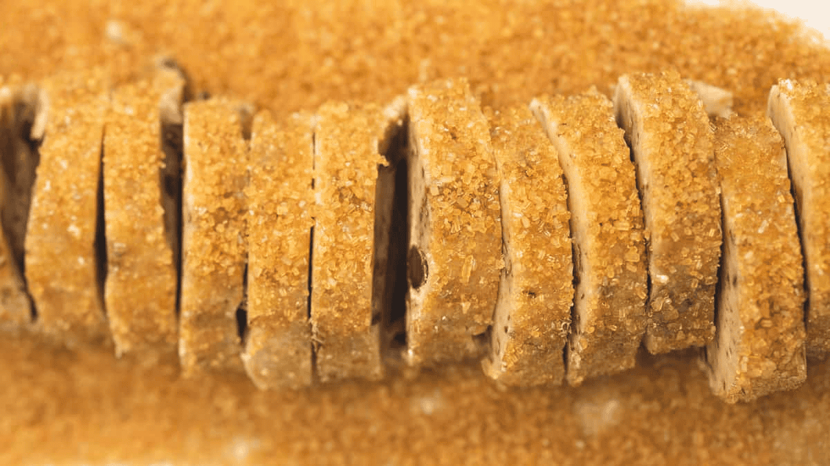 A sliced log of cookie dough coated with turbinado sugar.