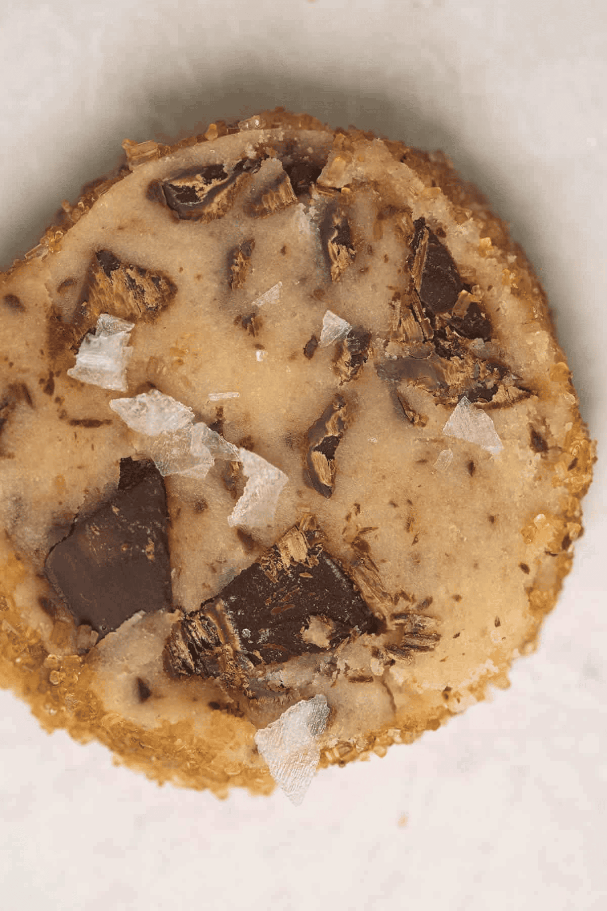 Unbaked Salted Chocolate Chunk Shortbread Cookie with flaky salt on top.