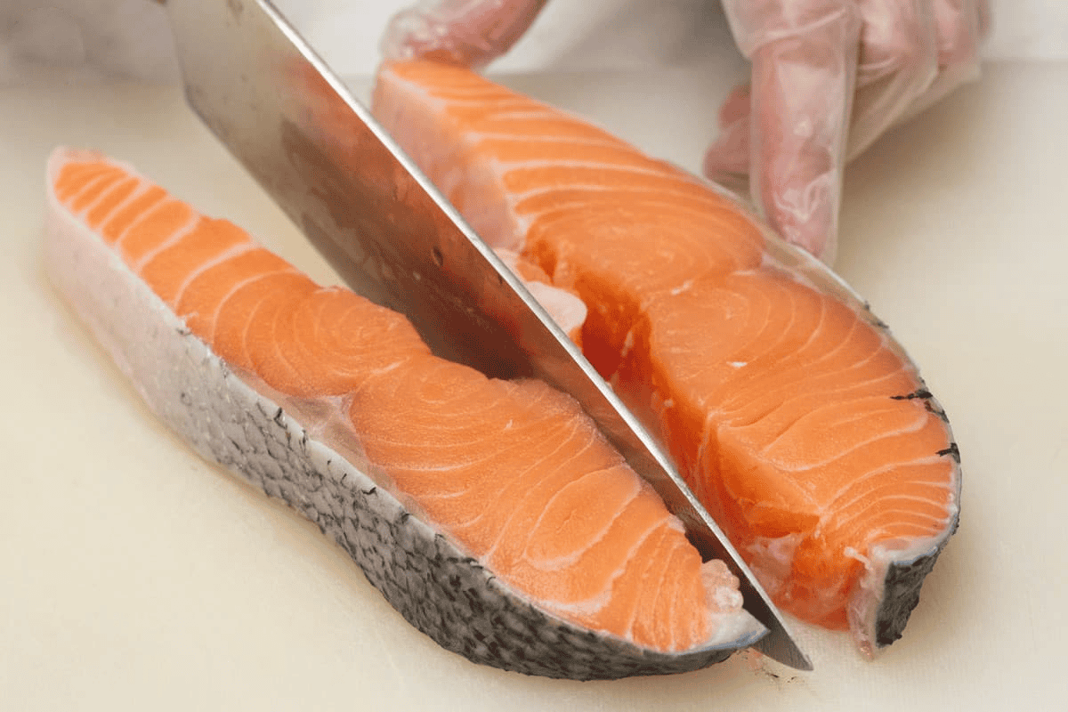 Cutting the salmon steak in half.
