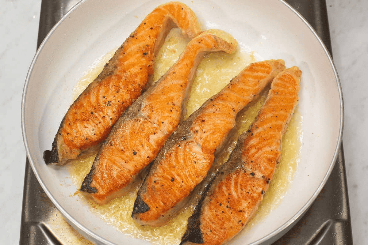 Searing the salmon in the pan.
