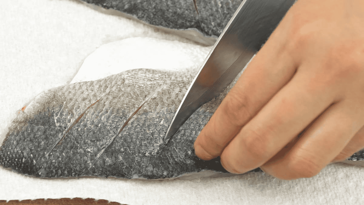 Cutting slits on the fish.