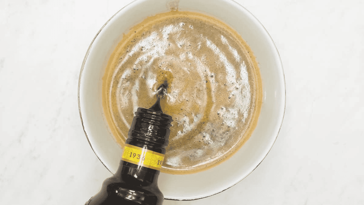 Adding liqueur to the coffee in the bowl.