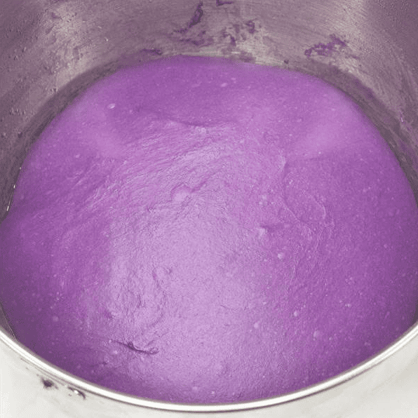 Ube dough after rising in a bowl.