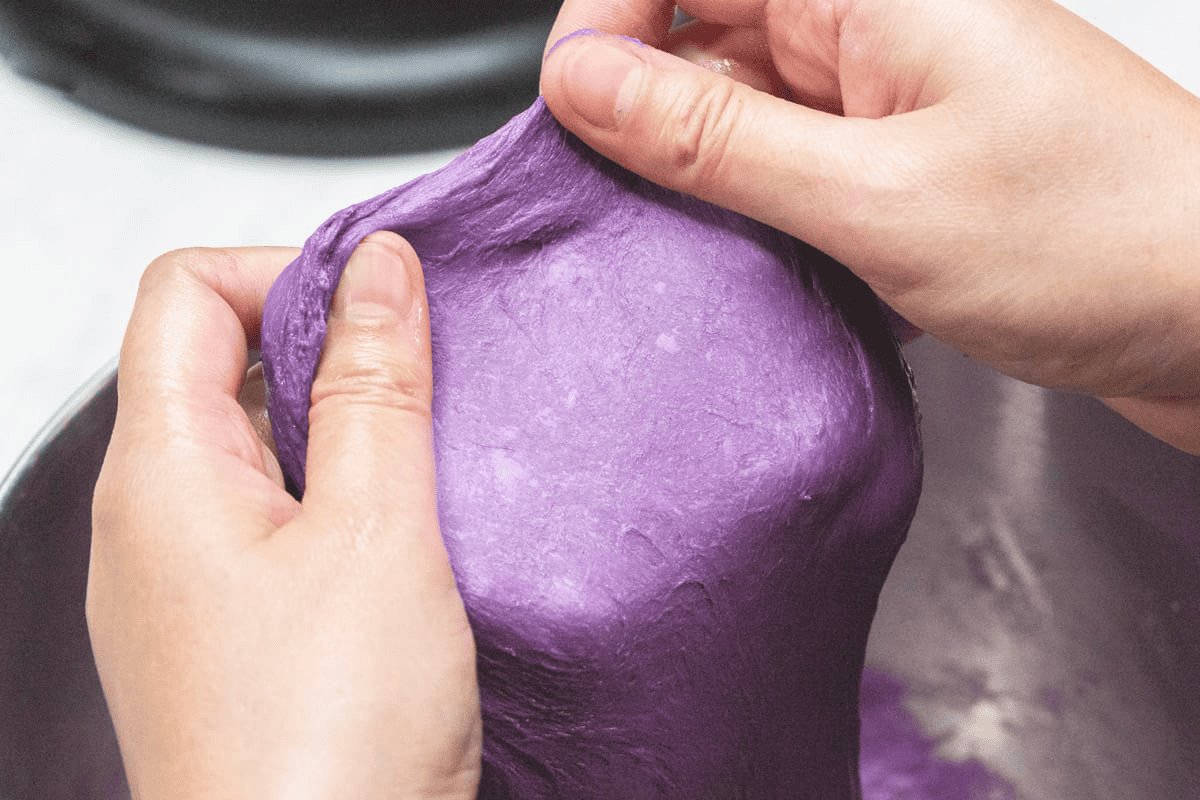 Stretching the dough thin using hands.
