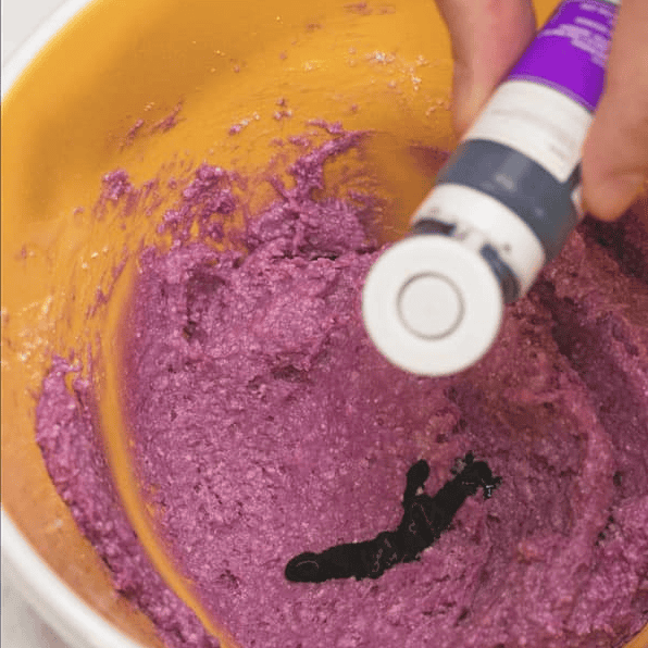 Adding ube flavoring to the purple mixture.