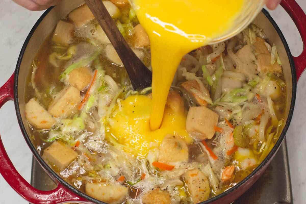 Adding the beaten eggs into the soup.