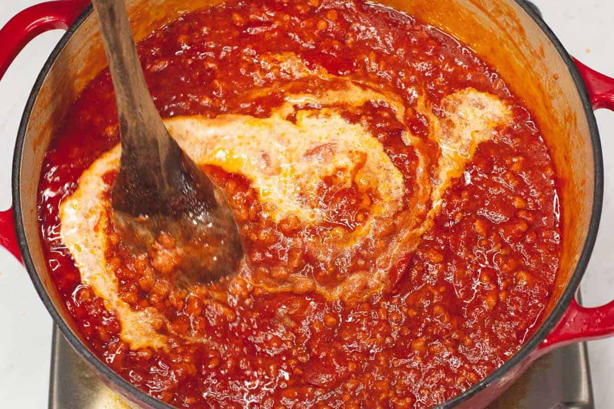 Mixing the milk into the sauce.