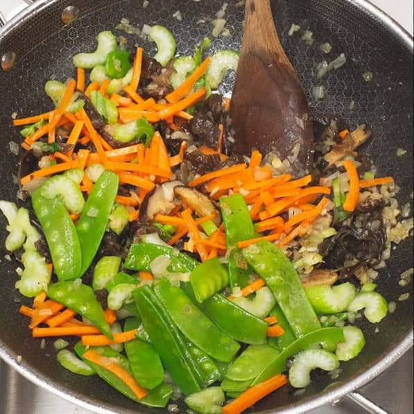 Stir frying the vegetables in a wok, then added the cabbage to the mix. 