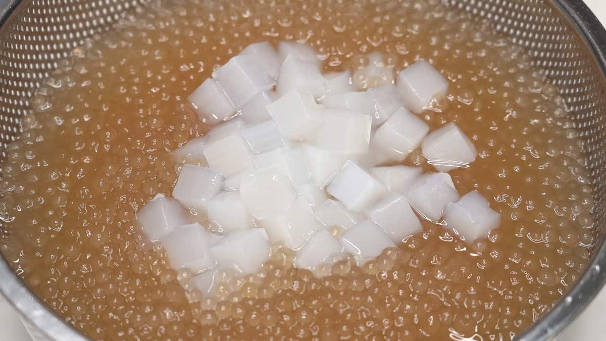Draining sago and nata de coco in a strainer.