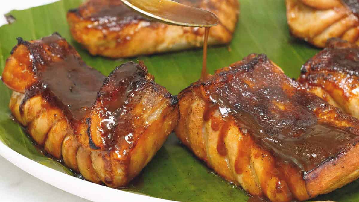 Adding sauce to the cooked tuna belly slices.