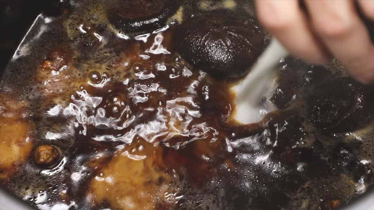 Adding cornstarch slurry to the sauce.