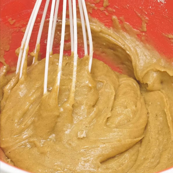Combining the dry and wet ingredients in a bowl. Mixing the dry and wet ingredients using a whisk.