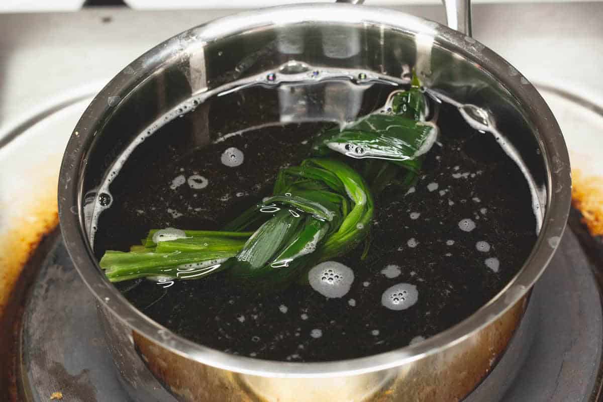 Combining the ingredients for brown sugar syrup (arnibal) in a saucepan.