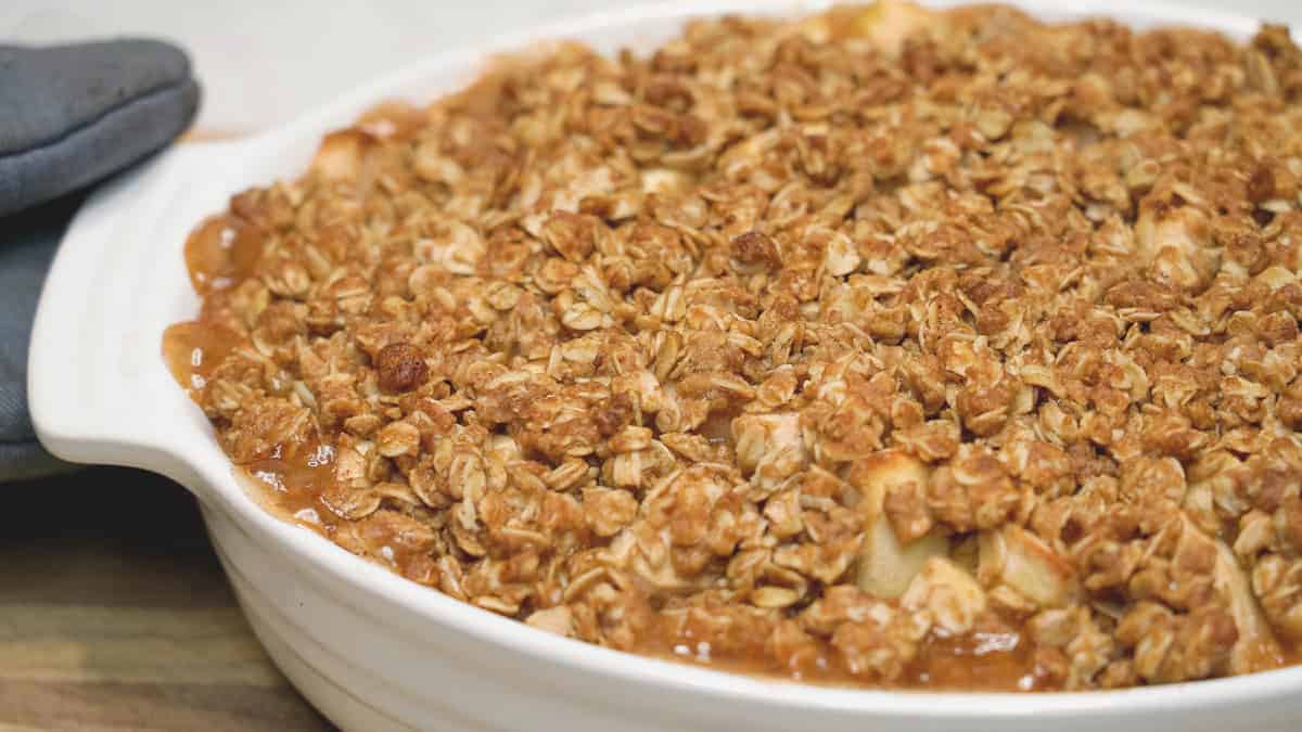 Easy Apple Crisp with Crunchy Oat Topping bubbling around the edges in the baking dish.