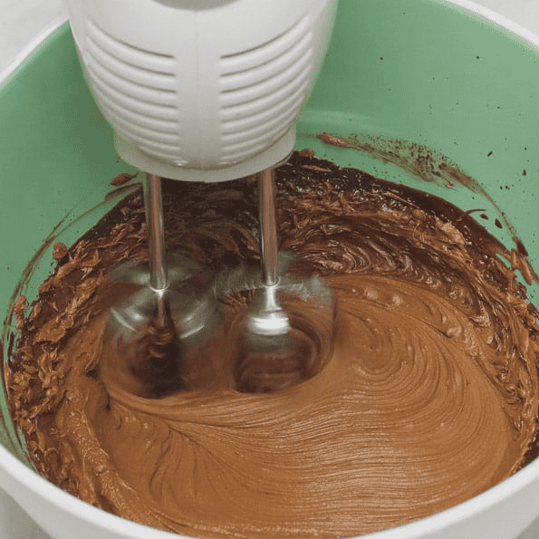 Whipping chocolate ganache with a hand mixer.