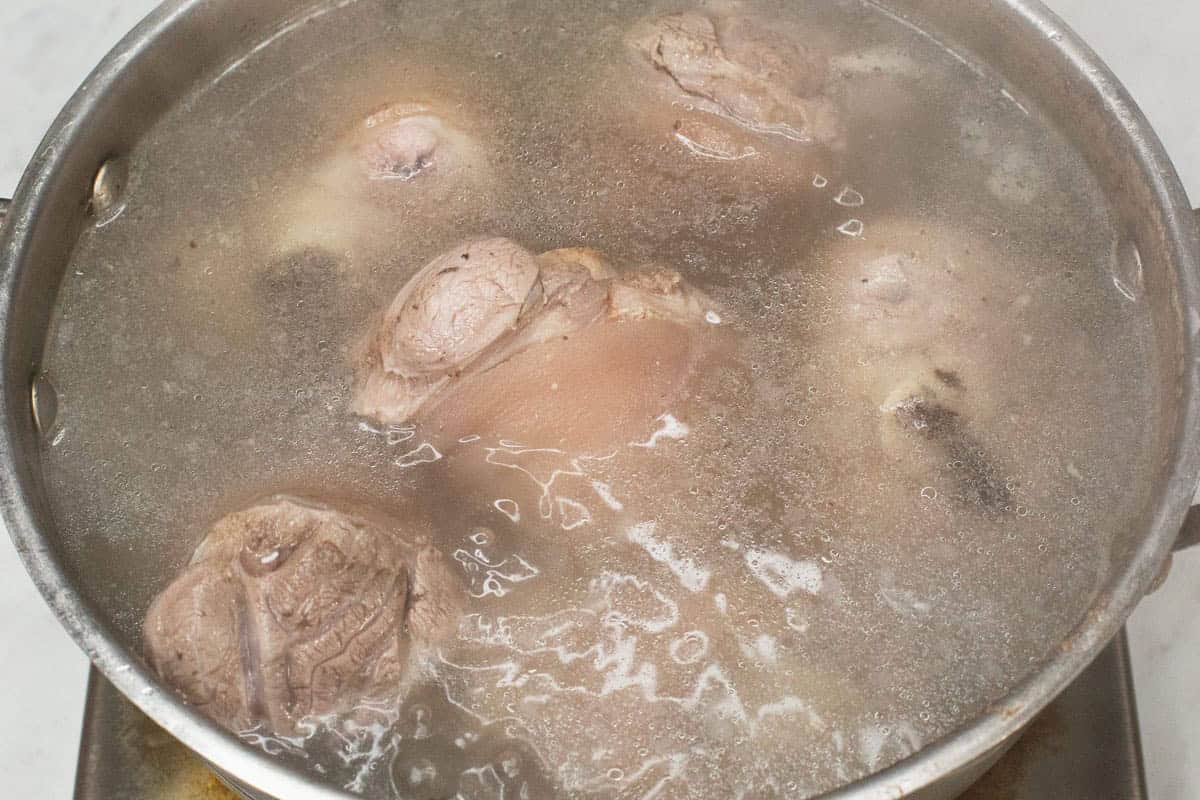 Boiling the pork hock in a pot of water.