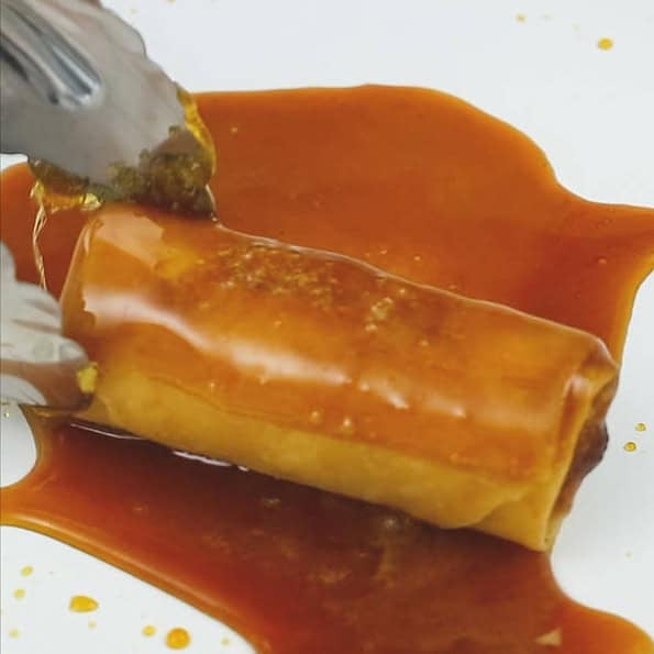 Caramelizing sugar on the pan. Coating the turon in caramel.