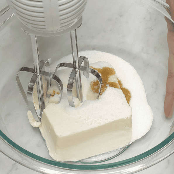 Mixing cream cheese, sugar and vanilla with a hand mixer.