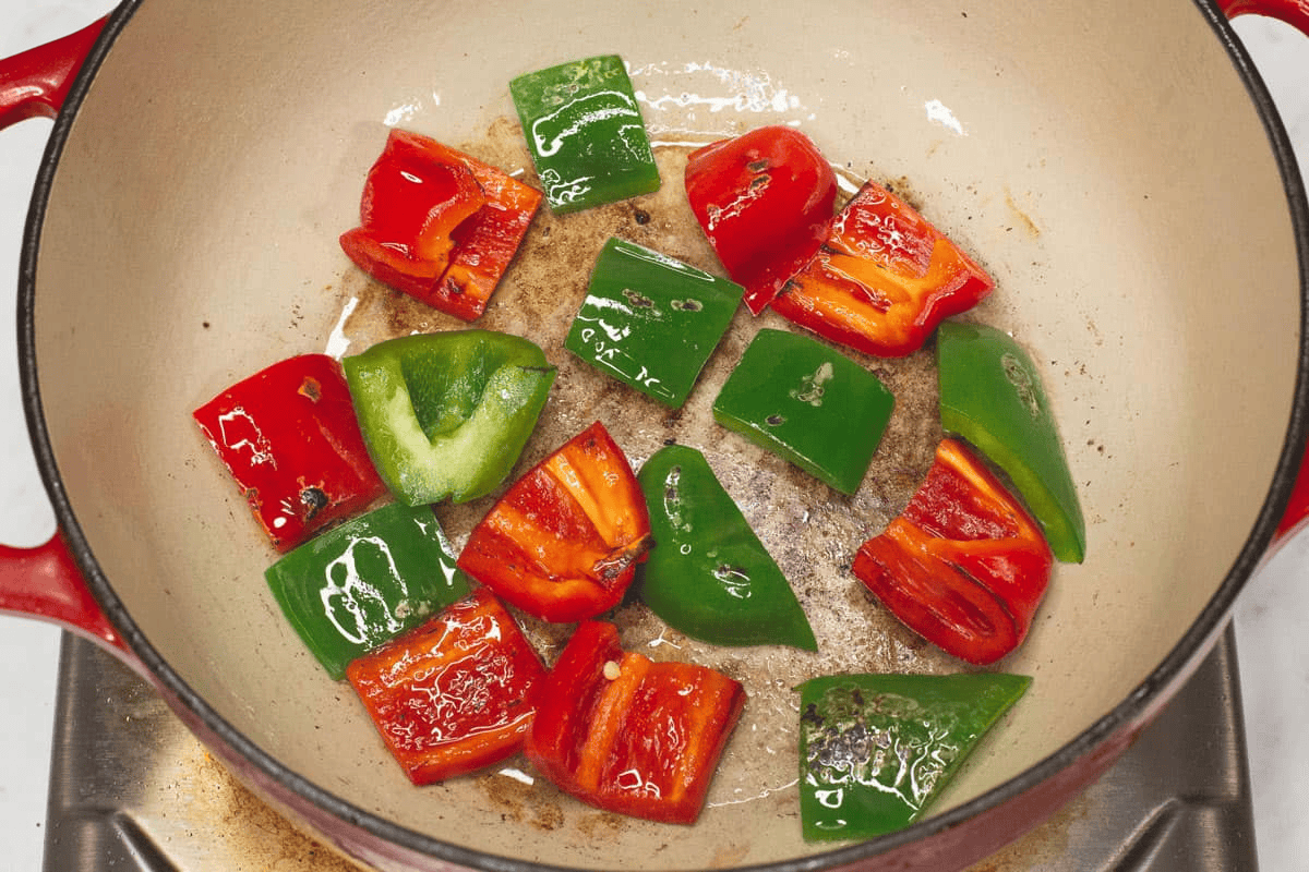 Searing the red and green bell peppers in the pot.