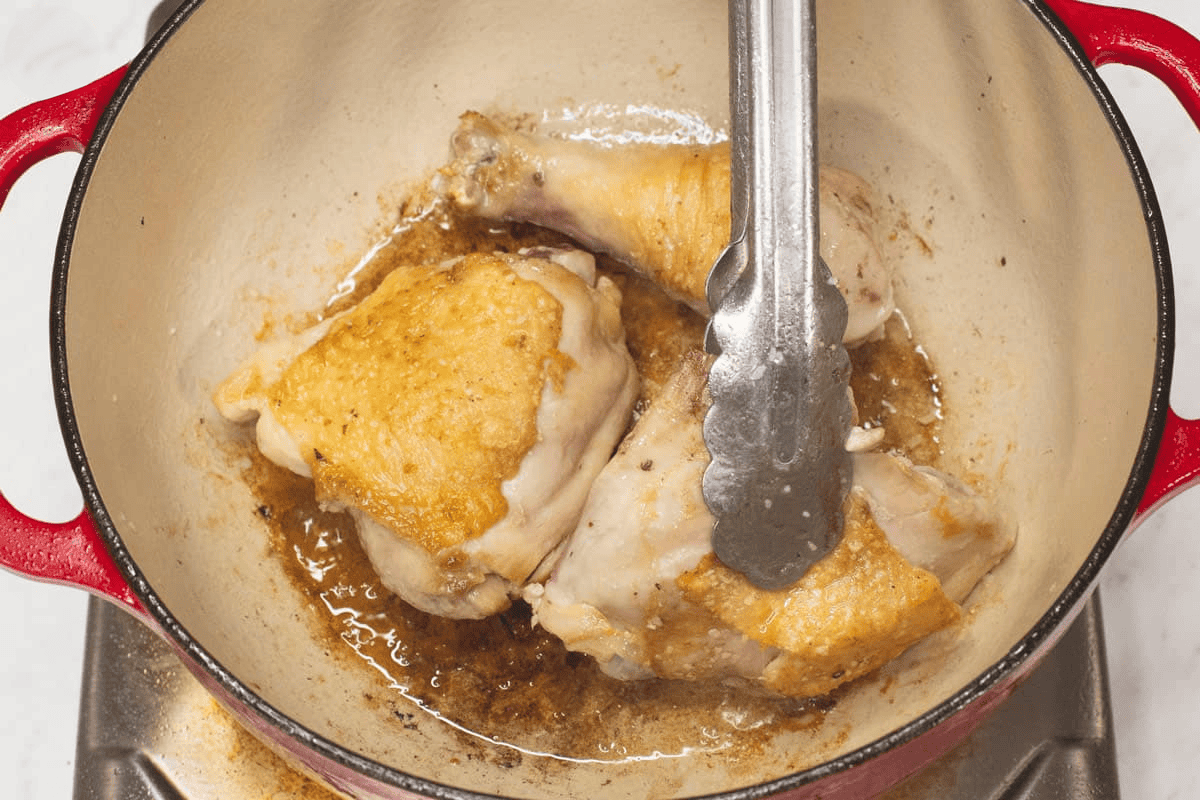 Searing the chicken in the pot.