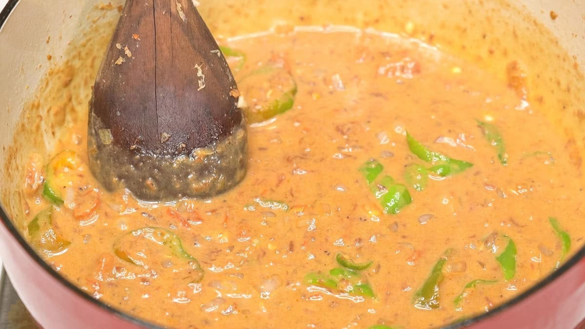 Mixing the sauce with coconut milk in the pot.