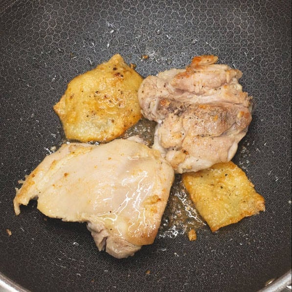 Searing the chicken in a wok, then shredding it on a cutting board.