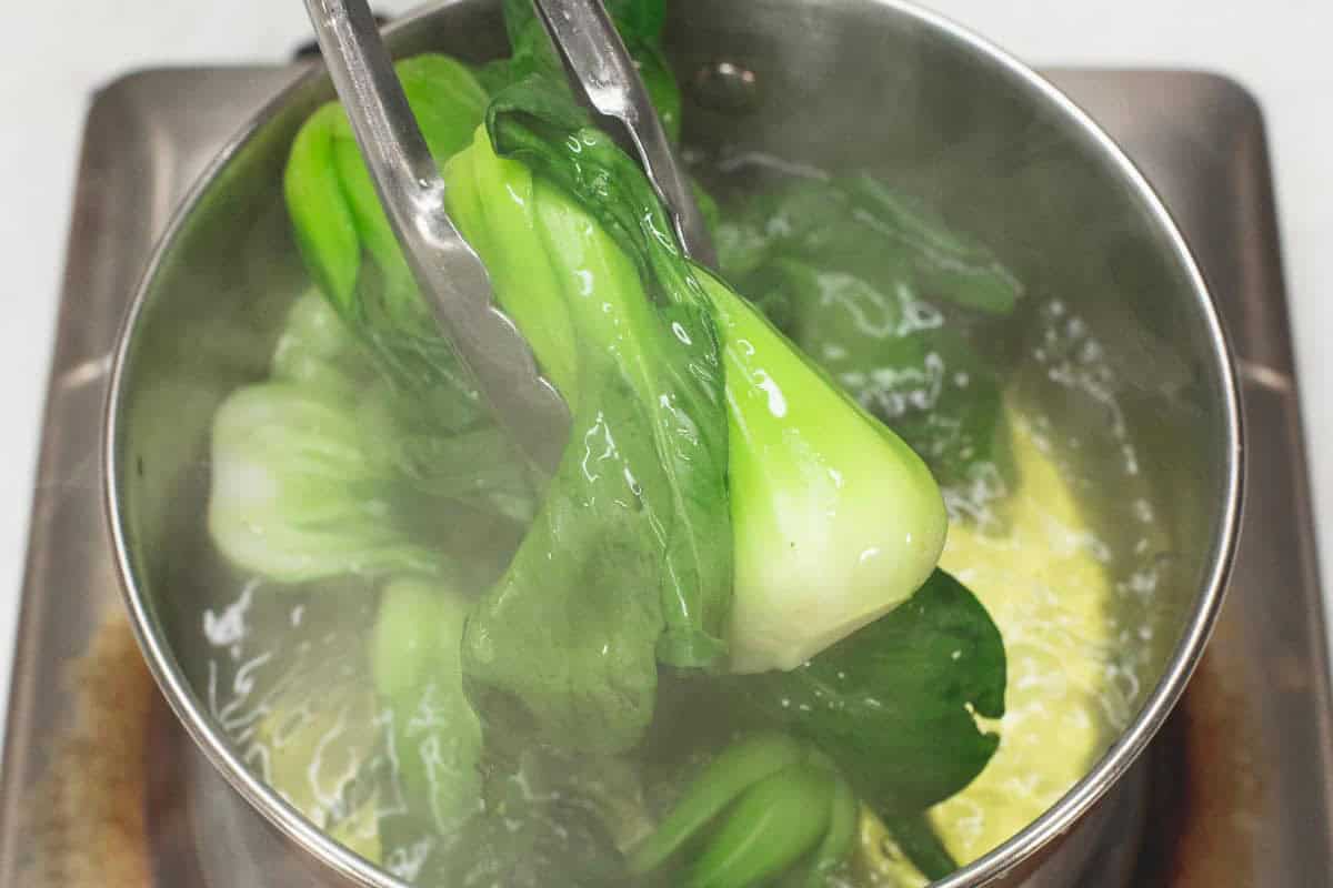 Blanching the bokchoy in boiling water.