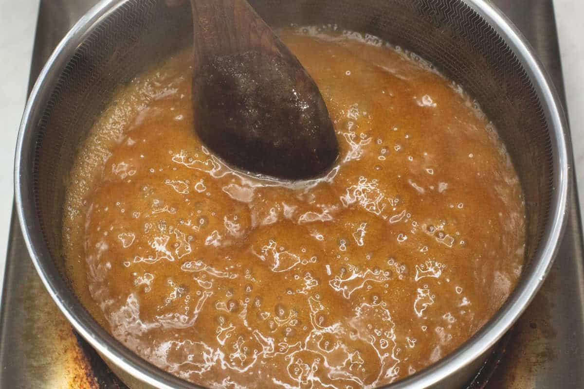 Simmering latik sauce in the saucepan.